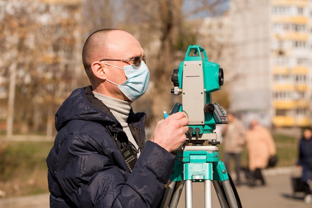 Surveyor em uma máscara protetora funciona