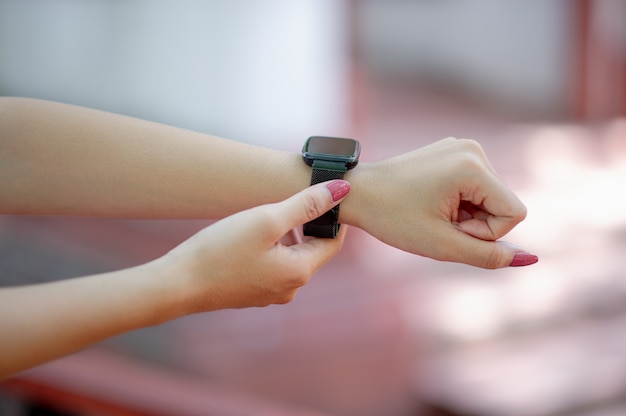 Sus manos y su reloj de pulsera negro. Conocer el tiempo, concepto, tiempo.