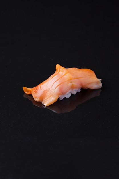 Sushi Akagai sobre un fondo oscuro