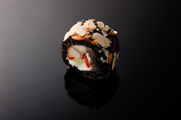 Sushi con anguila sobre un fondo negro con reflejo. Fotografía macro.