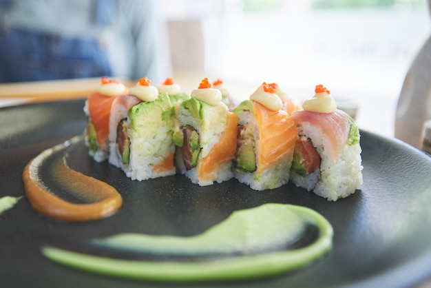 Sushi asiático y plato de comida en un restaurante para la cena o el almuerzo en una cafetería japonesa saludable en la mesa Cocina de platos y buena comida para llevar o mariscos de un menú de salmón para dieta o nutrición