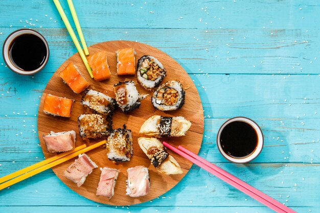 Sushi auf rundem Holzbrett blauen Tisch