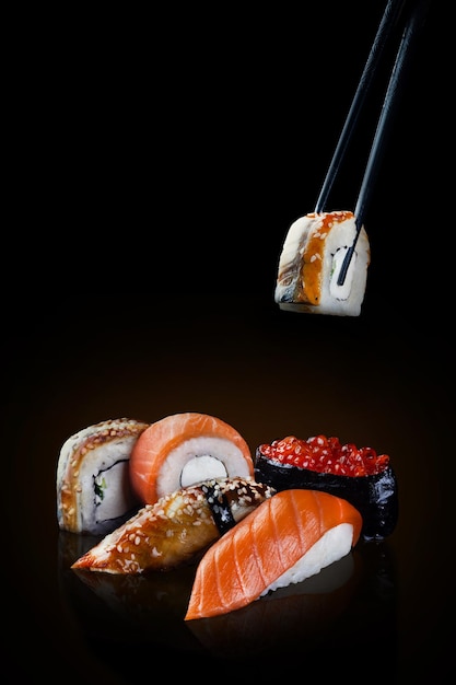 Sushi auf schwarzem Hintergrund Sushi Nigiri Kaviar und Sushi mit Aal mit Stöcken