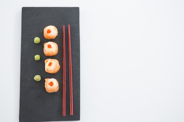 Sushi auf Tablett mit Stäbchen serviert