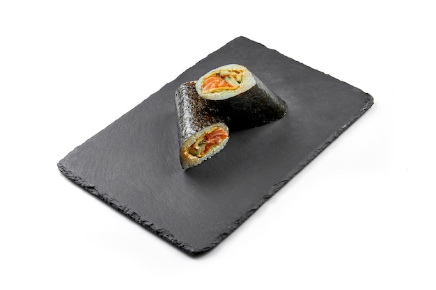 Sushi-Burrito mit Lachs in Nori auf schwarzem Brett Closeup selektiver Fokus Weißer Hintergrund