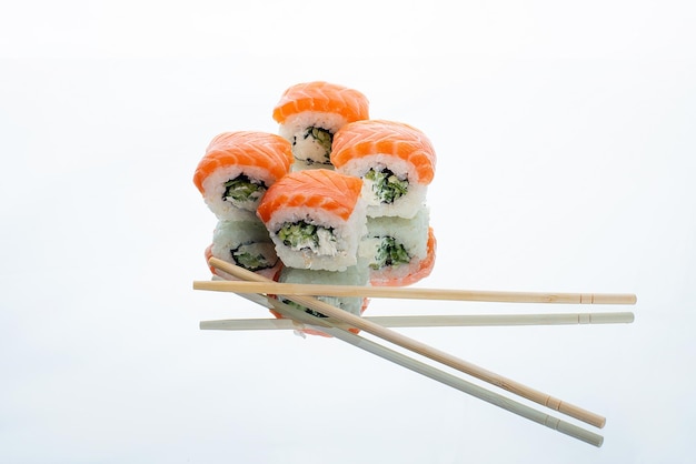 Sushi com arroz e salmão em um fundo de vidro com pauzinhos restaurante japonês