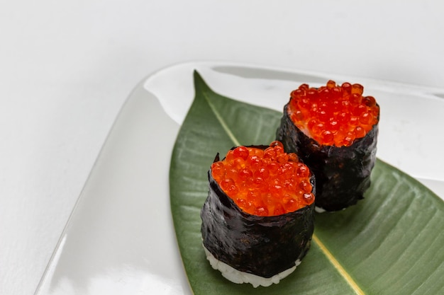 Sushi com caviar em uma folha verde