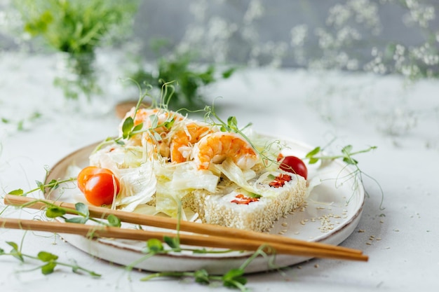 Sushi com legumes e camarões em um prato branco decorado com microgreens