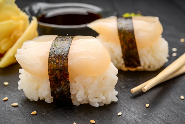 Sushi com vieiras em um preto