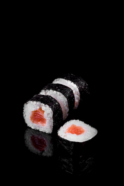 Foto sushi de atum makis em um fundo preto. comida asiática