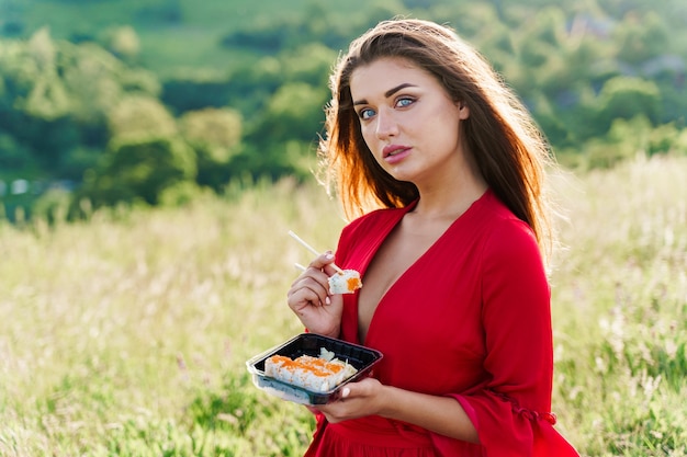 Sushi e garota sexy com olhos azuis no piquenique. entrega de comida de restaurante japonês.