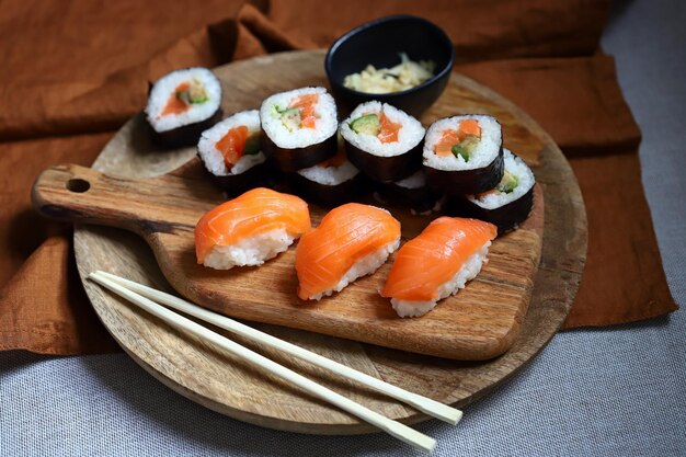 Sushi e pãezinhos com abacate e salmão em uma tábua de madeira