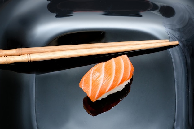 Sushi e pauzinhos na chapa preta.