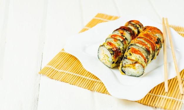 Foto sushi em prato branco moderno e palitos