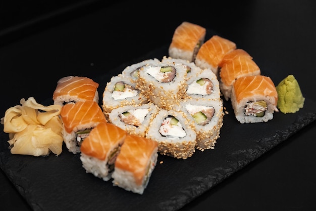 Sushi em um prato de pedra com fundo preto