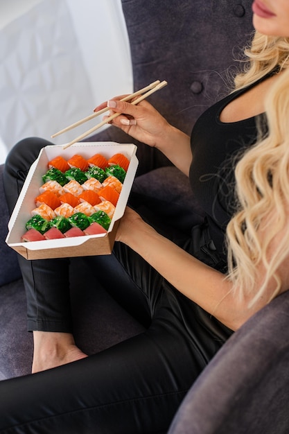 Sushi essen mit stäbchen nahaufnahme essen zum mitnehmen und lieferservice lachs-sushi-rollen leckere mahlzeit sushi-lieferung