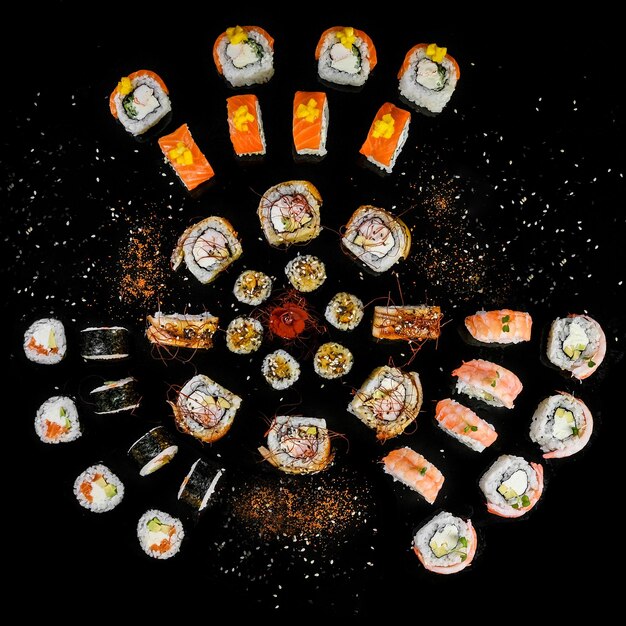 Sushi establecido en fondo negro vista superior variedad de sushi fresco y delicioso en un restaurante oriental