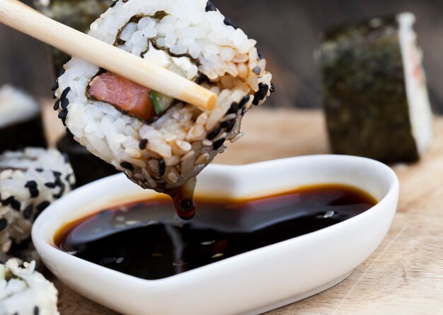 Sushi feito de arroz branco, truta e abacate, produtos vegetais prontos para o consumo e peixe-salmão vermelho