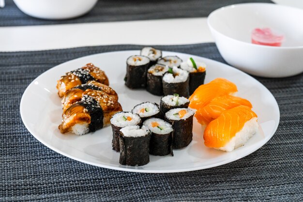 Sushi fresco e rolos em um prato branco. almoço de sushi.