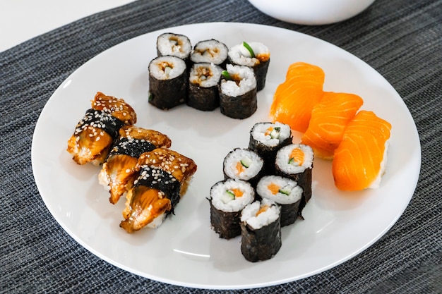 Sushi fresco e rolos em um prato branco. Almoço de sushi.