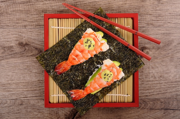 Sushi de gambas y aguacate con palillos, vista desde arriba