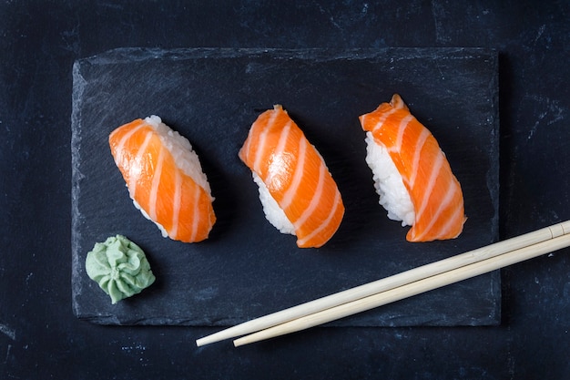 Sushi gourmet servido em prato de ardósia preta