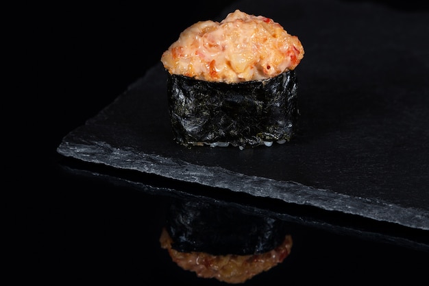 Sushi Gunkan con salmón picante en escritorio negro