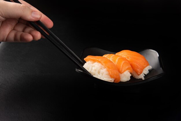 Sushi, Hände, die Sushi mit Haschi pflücken
