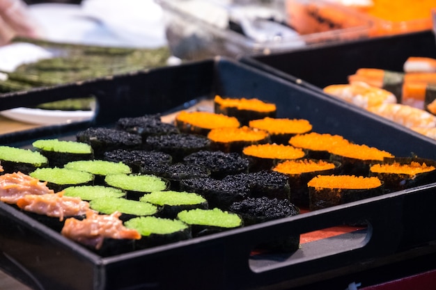 Foto sushi japonês do alimento na caixa plástica na tabela japonesa. comida japonesa de estilo original.