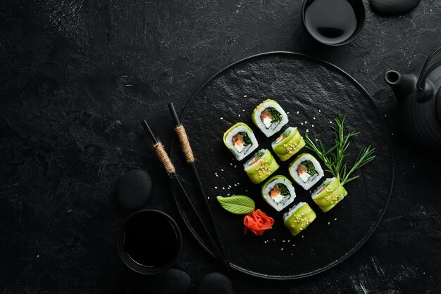 Sushi japonês dragão verde abacate cebola salmão e sushi queijo vista superior