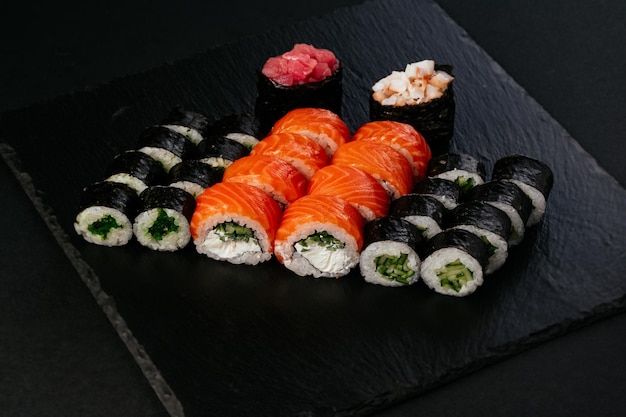 Sushi japonés fresco sobre un fondo negro