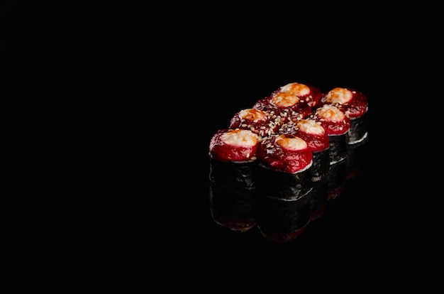 Sushi japonês - rolo isolado em um fundo preto brilhante.