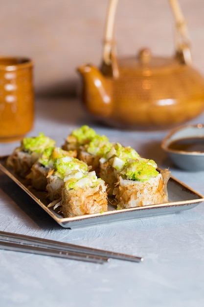 Sushi, jengibre y salsa de soja, comida japonesa y té, estilo asiático para servir comida, rollos