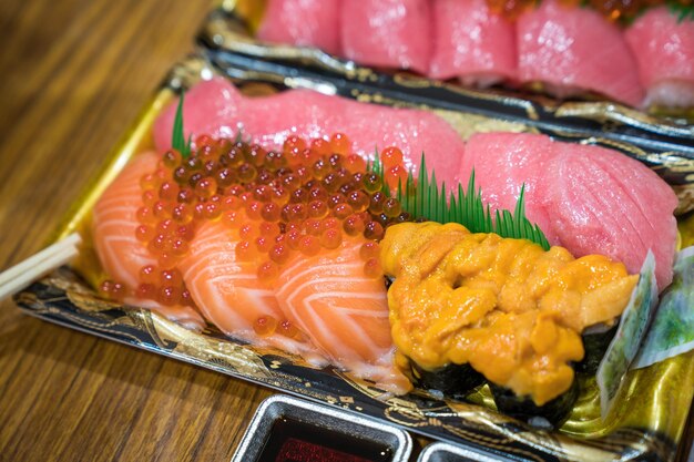 Sushi Lachs und andere Sushi werden auf dem Kuromon Fish Market Osaka Japan in einer Schaumpflanze auf dem Tisch verzehrfertig arrangiert