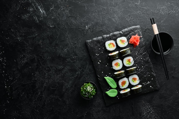 Sushi maki com salmão, abacate e nori Espaço livre para o seu texto Cozinha tradicional japonesa Vista superior Estilo rústico