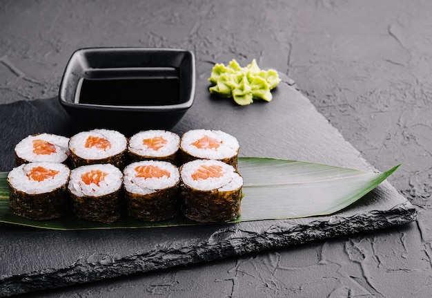 Sushi maki grande japonés en tablero negro