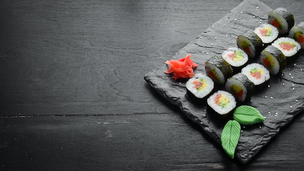 Sushi Maki mit Lachs, Avocado und Nori Freier Platz für Ihren Text Japanische traditionelle Küche Draufsicht Rustikaler Stil