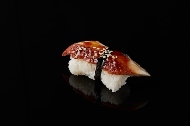 Sushi mit Aal auf einem schwarzen Hintergrund