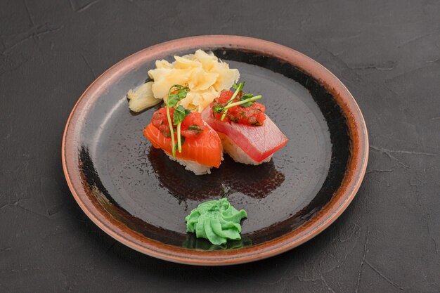 Sushi mit Lachs und Thunfisch auf schwarzem Hintergrund