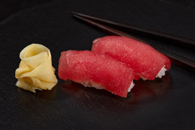 Sushi-Nigiri mit Thunfisch auf schwarzem Hintergrund