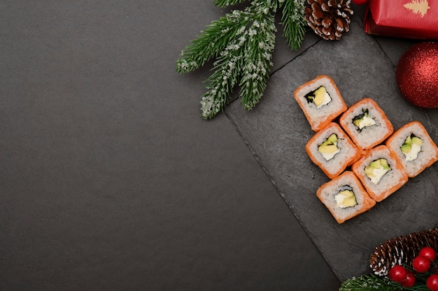 Sushi para o conceito de Natal. Árvore de Natal comestível mde da Filadélfia roll on black