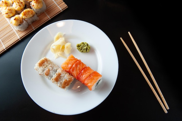 Sushi en un plato blanco sobre un fondo negro