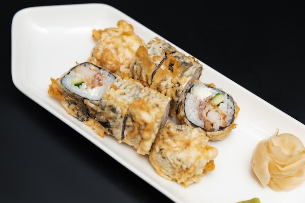 Sushi en un plato de piedra con fondo negro