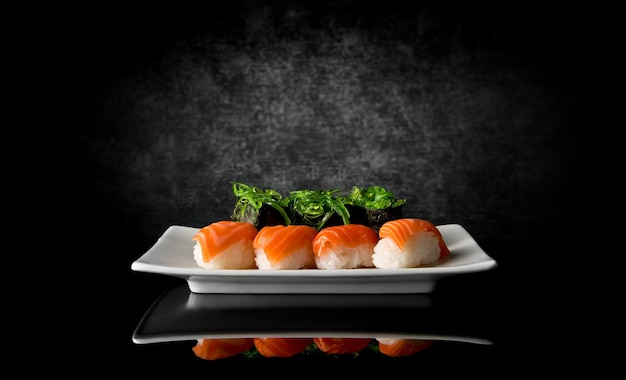 Sushi en plato sobre un fondo negro