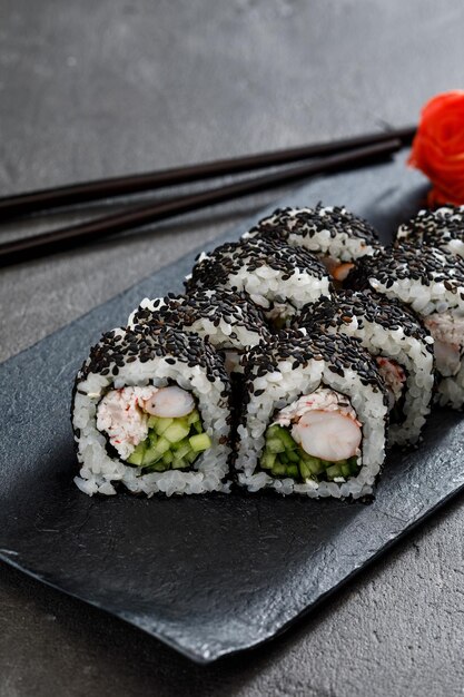 Sushi en un plato sobre una mesa de piedra gris