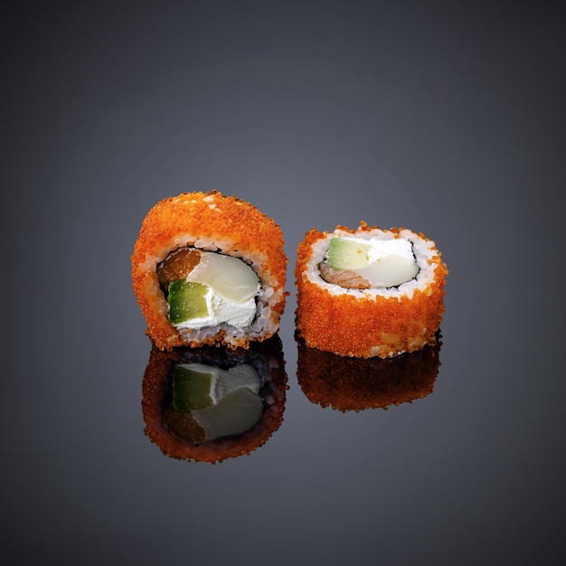 Un sushi que está sobre un fondo negro.