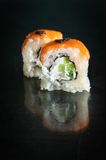 sushi rola peixe salmão, legumes, arroz de gengibre wasabi e nori na mesa