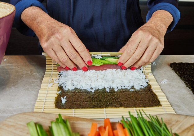 Sushi rolando com tapete de bambu