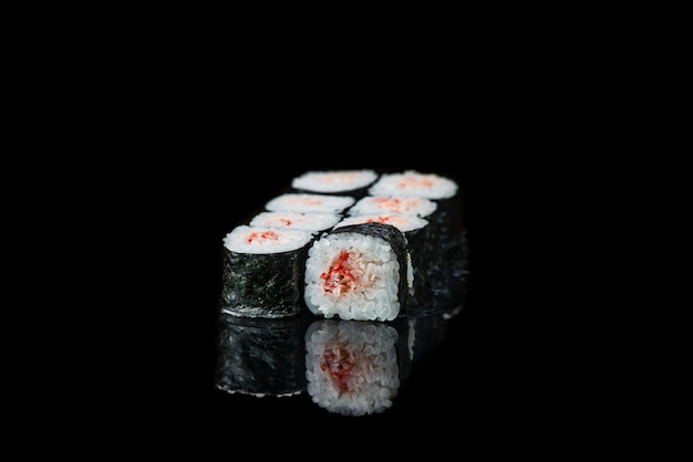 Sushi-Rolle auf einer schwarzen Hintergrundreflexion japanisches Essen schließen