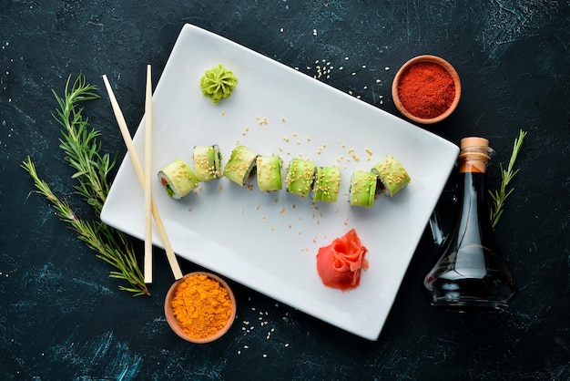 Sushi-Rolle mit Avocado-Gurke und Tomate Japanische Küche Draufsicht auf schwarzem Hintergrund